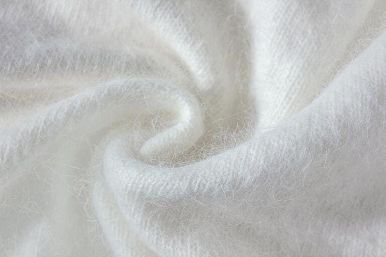Swirl of white alpaca fabric and mohair wool sweater texture