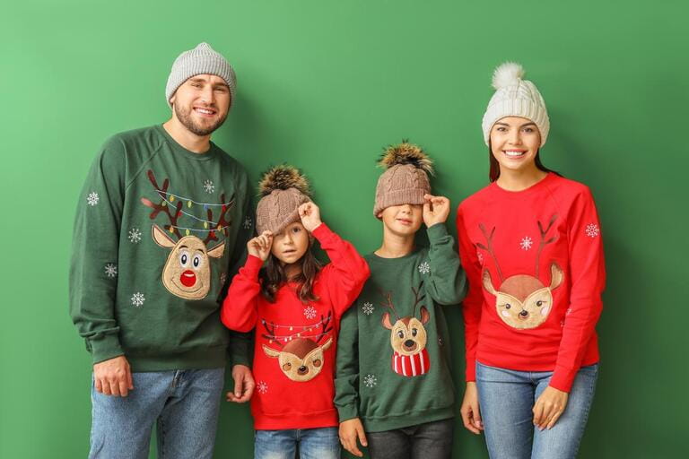 Happy family in Christmas sweaters on color background Happy family in Christmas sweaters on color background