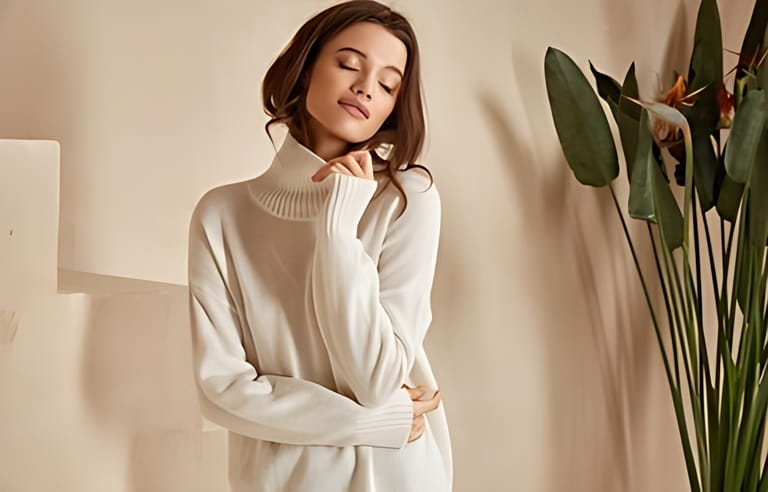 Beautiful sexy woman brunette hair fashion model beautiful face wearing casual trend clothes for day out summer collection white sweater and beige skinny shorts interior background stairs boho flowerpot.