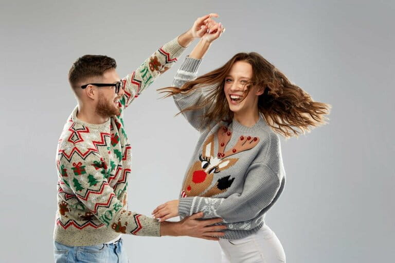 Couple dancing at ugly Christmas sweater party Couple dancing at ugly Christmas sweater party