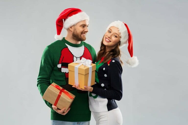 Happy couple in Christmas sweater with gifts Happy couple in Christmas sweater with gifts