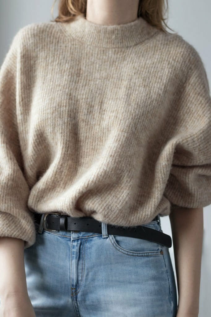 a girl dressed in sweater and jeans, belt
