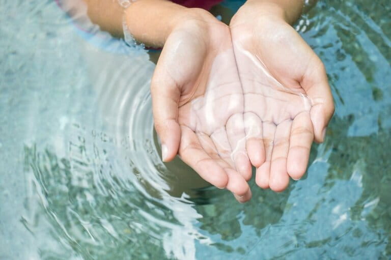 Cleaning natural water in woman's hands